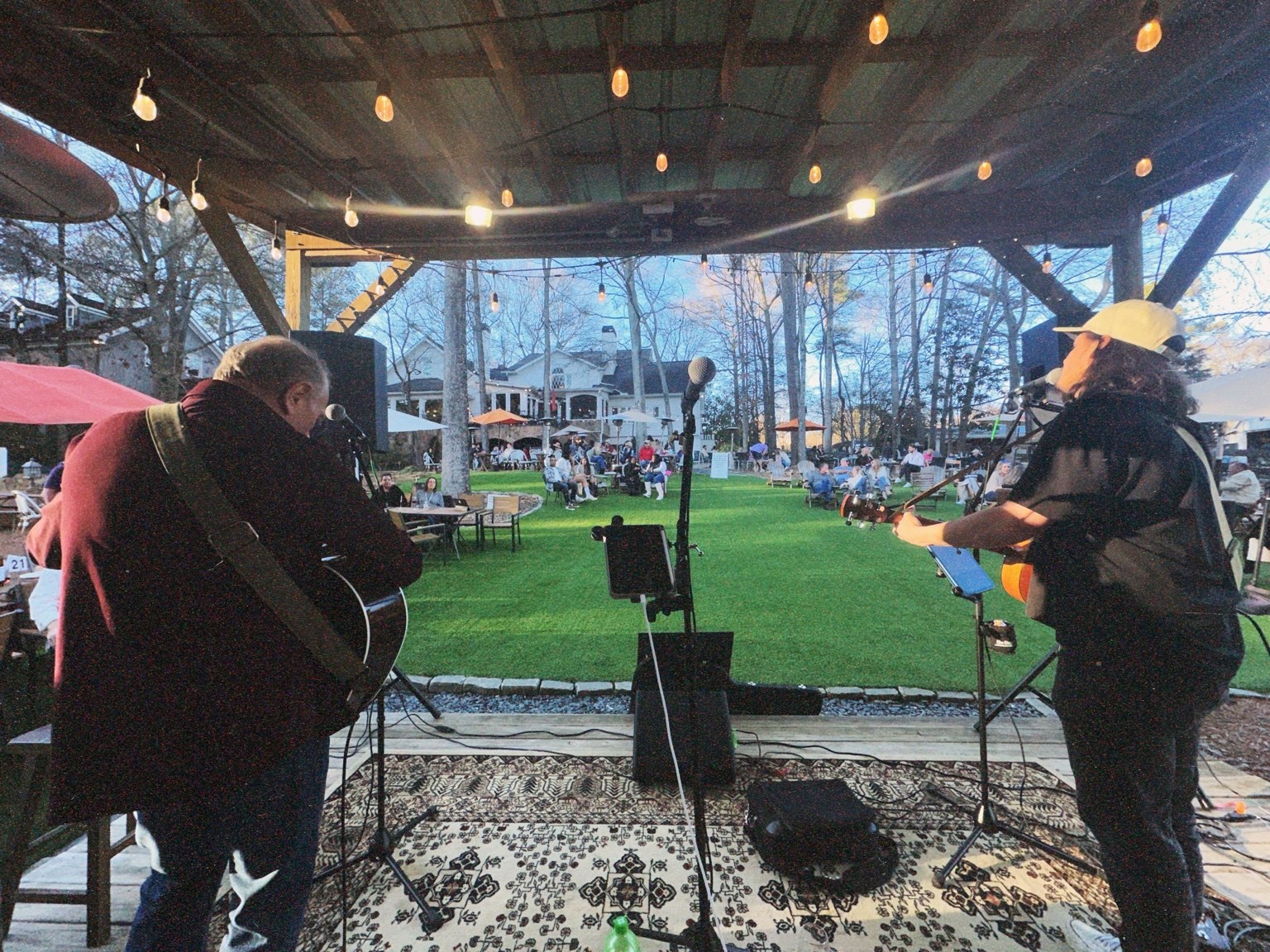 Nic Elliott and Dallas playing guitars on an outdoor stage overlooking the audience
